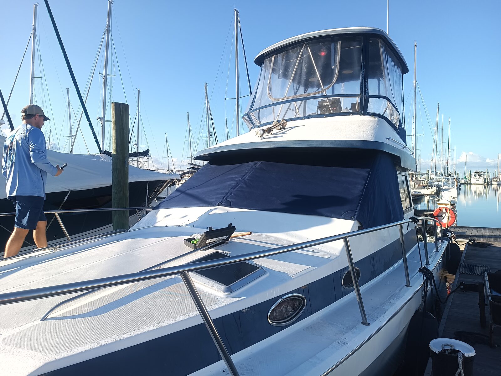 Flybridge boat with a navy insulated windshield cover installed