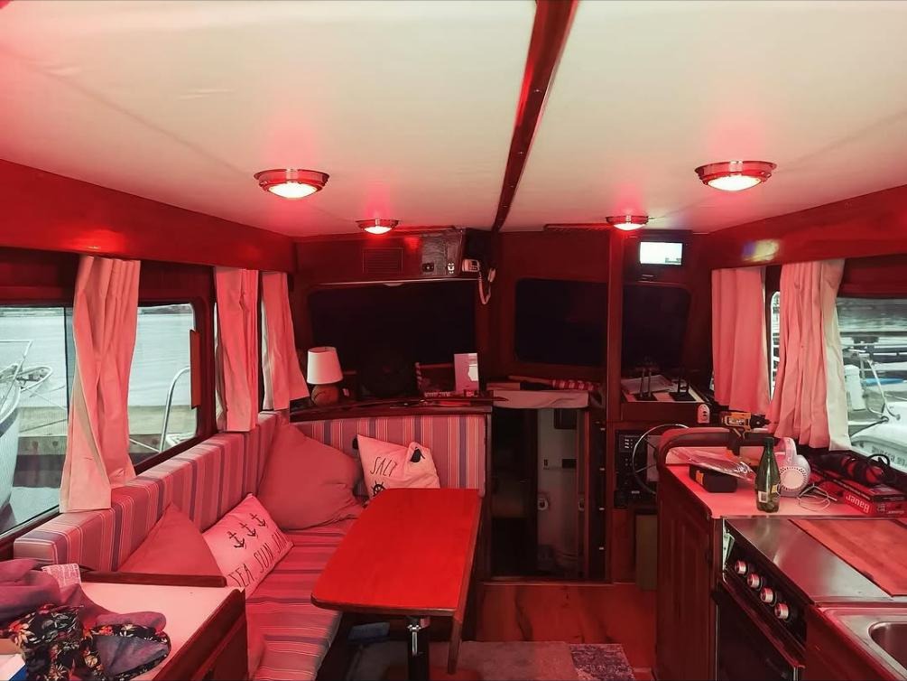 Boat salon with cushioned settee, dinette, and galley